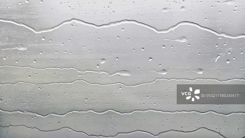 在高铁列车窗外，暴雨倾盆，雨水在玻璃上，平行于列车，连成线。图片素材