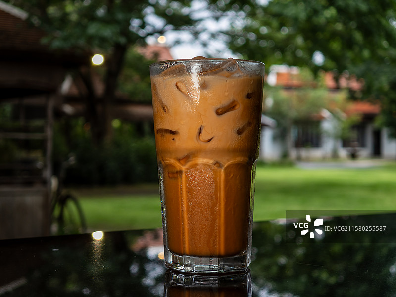 放在户外的木桌上的泰式冰奶茶图片素材
