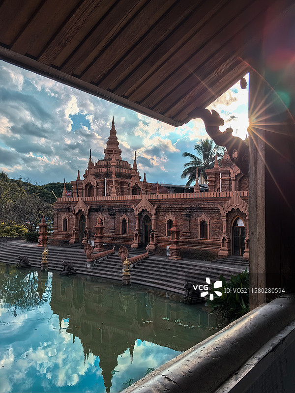 金顶寺庙在夕阳下更显庄重与神圣，水面倒影增添了宁静之美图片素材