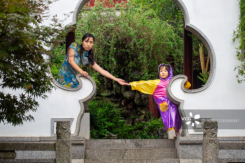 母女在园林拱门旁牵手图片素材