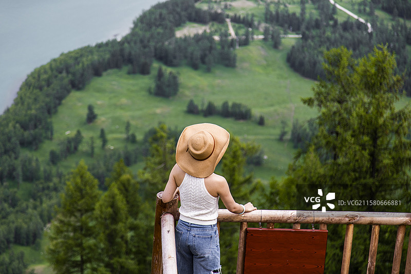 年轻女孩在新疆喀纳斯观鱼台欣赏美丽风景图片素材