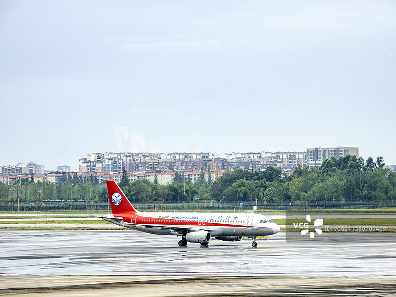 红色涂装客机在跑道上滑行准备起飞图片素材