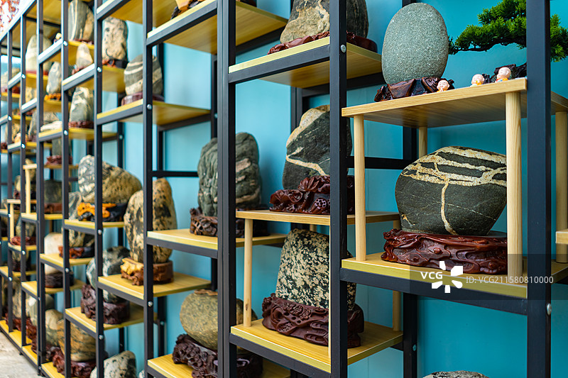 中国奇石拍摄主题，木制底座上放着形态各异的泰山石奇石装饰品，户外白昼无人图像摄影图片素材