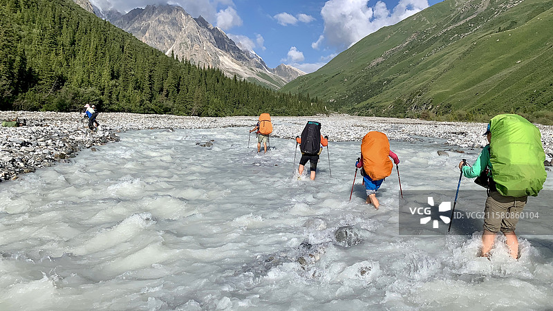 新疆南天山徒步穿越中的徒步者正在过河图片素材