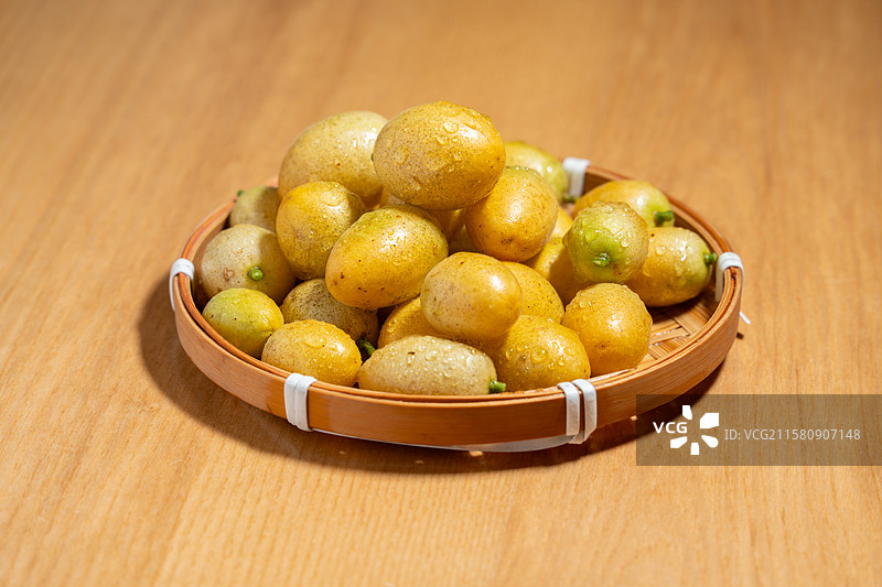 木纹桌上新鲜的特色水果黄皮果图片素材