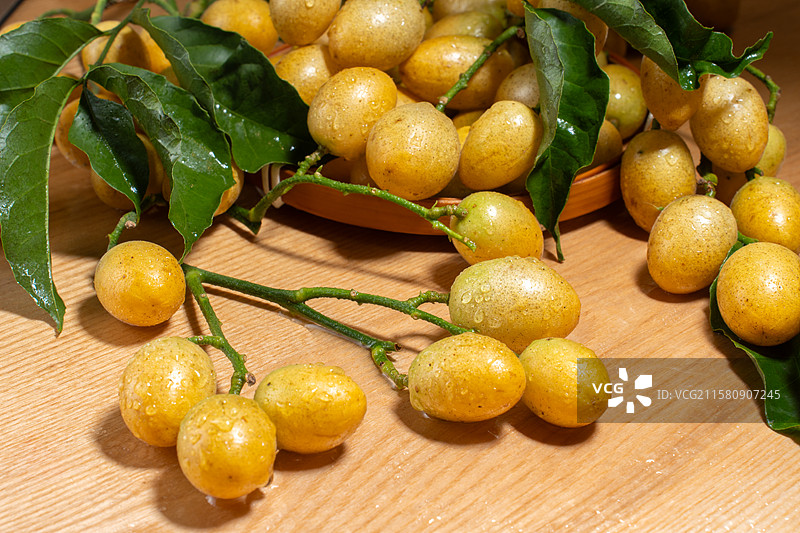 木纹桌上新鲜的特色水果黄皮果图片素材