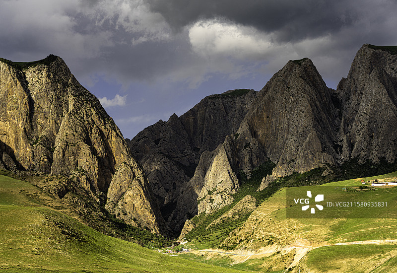 甘南甘加秘境中的白石崖峭壁耸立，岩石纹理清晰，映衬着厚重乌云，展现自然壮丽与神秘气息。图片素材