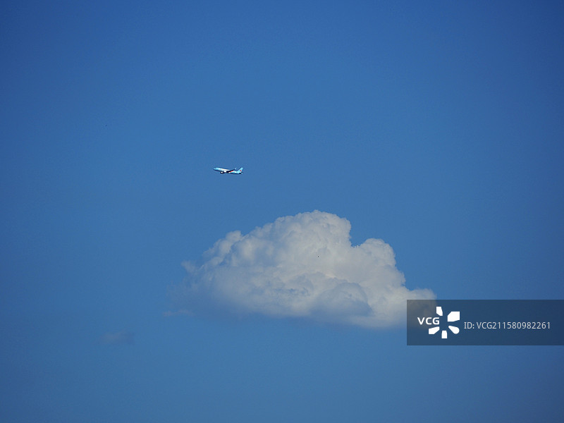 天空飞机飞过一朵云图片素材