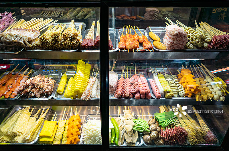 中国餐饮行业饮食产业，传统经典中国食品，夜市冰柜上的麻辣串炸串美食特写，户外夜晚无人图像图片素材