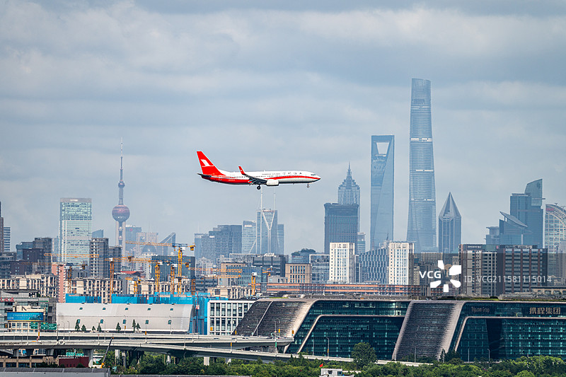 上海航空飞机在上海三件套前方飞过降落图片素材