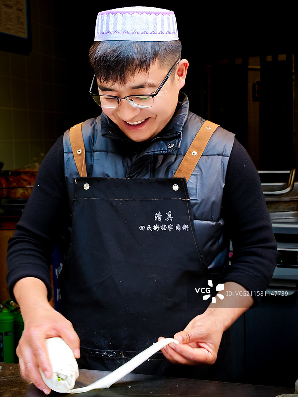乐在其中 西安袁家村回民街杨家肉饼店的肉饼生意不错，帅哥老板乐在其中。图片素材