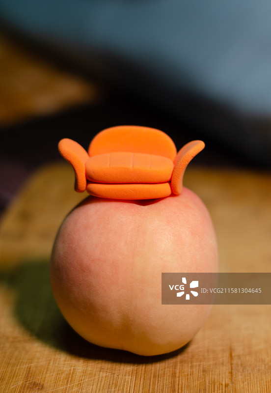 放在水蜜桃上的一个小沙发模型图片素材