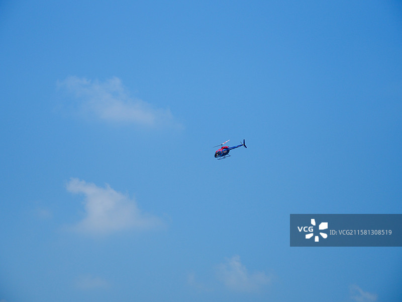 蓝天白云下的巡游的直升飞机图片素材