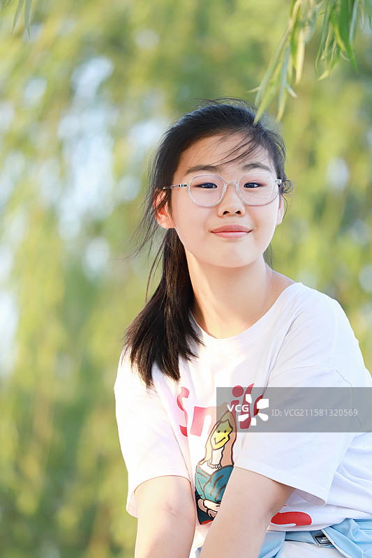 戴眼镜的青春少女微笑照图片素材