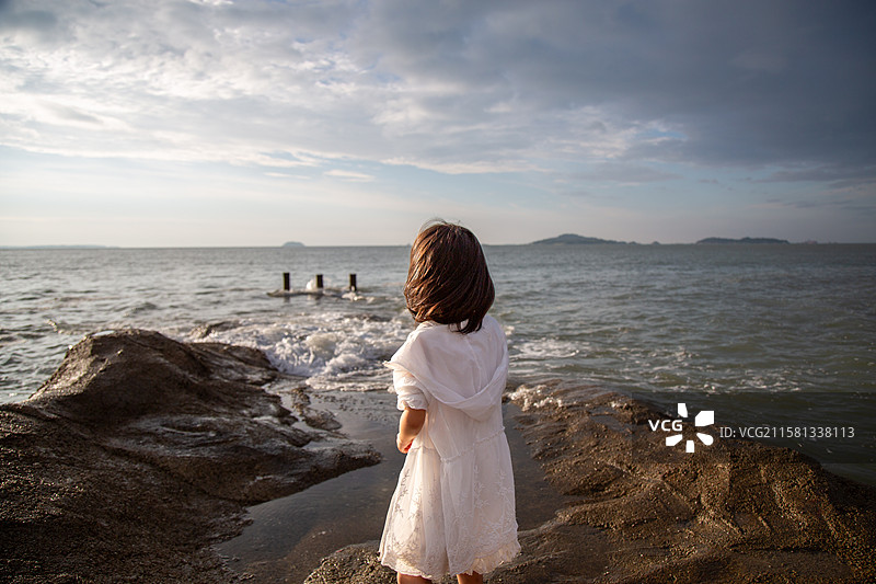 海边岩石上的女孩图片素材