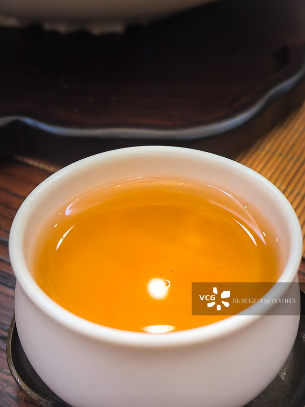 一杯普洱茶，金色的茶汤清亮，白色瓷杯清新，顿时好心情图片素材