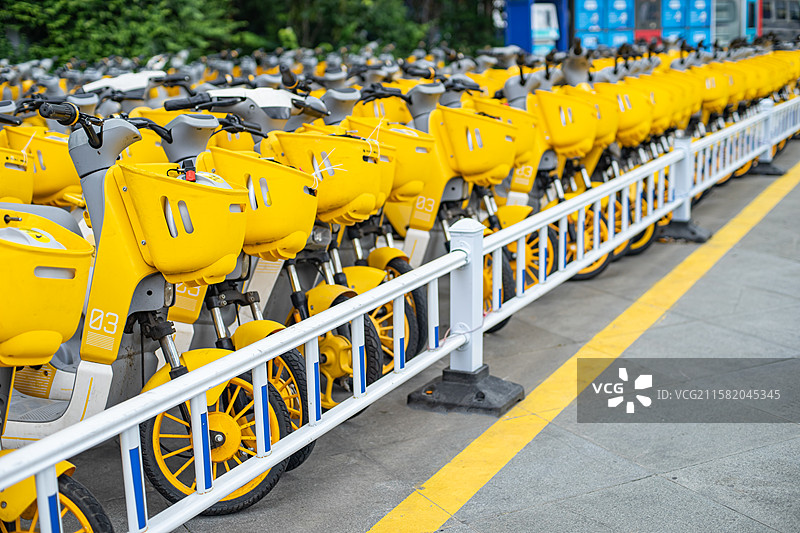 中国共享电动车拍摄主题，自行车停车场里，一排黄色的共享摩托车特写，户外白昼无人图像摄影图片素材