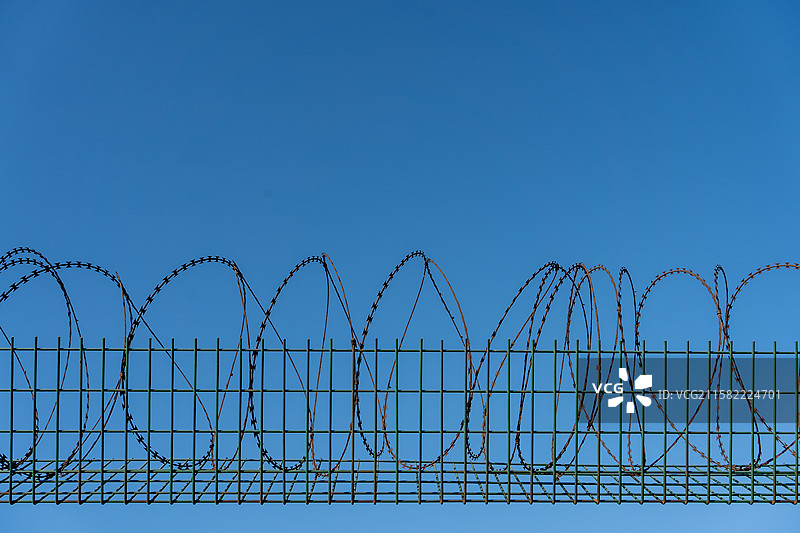 蓝天下带刺铁丝网的低角度视图图片素材