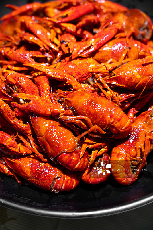 盛放在黑色盘子里的麻辣小龙虾特写图片素材