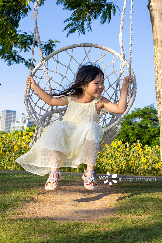 在公园里玩荡秋千的中国小女孩图片素材