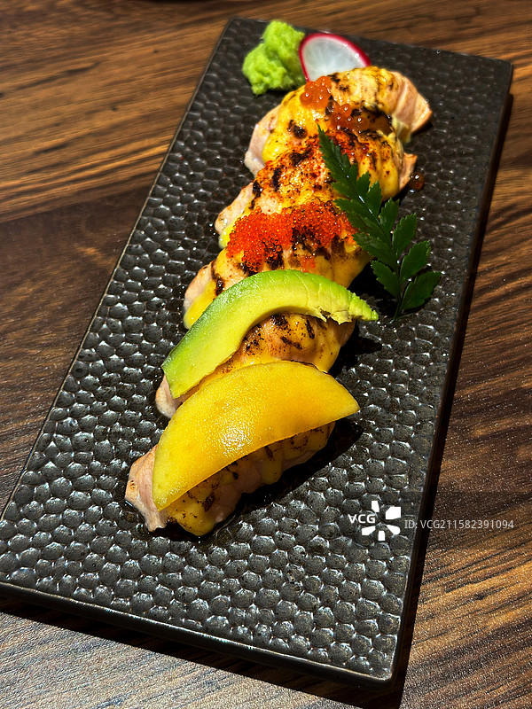 木质桌子上一个精致的招牌烧鸟寿司套餐炙烧牛油果鱼籽蟹籽香芒三文鱼美食图片素材