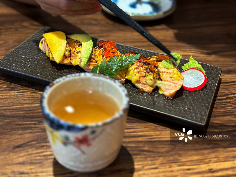 木质桌子上一个精致的招牌烧鸟寿司套餐炙烧牛油果鱼籽蟹籽香芒三文鱼美食图片素材