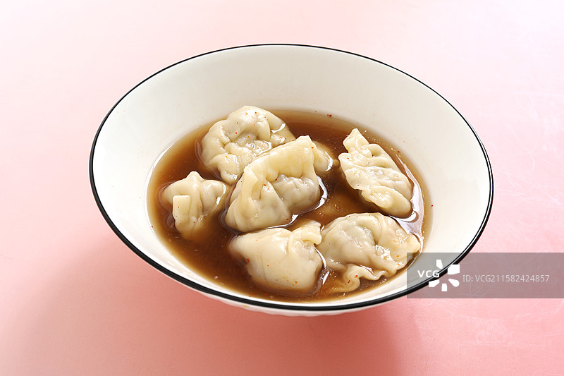 桌面上的一碗中国传统节日冬至春节美食饺子酸汤水饺图片素材