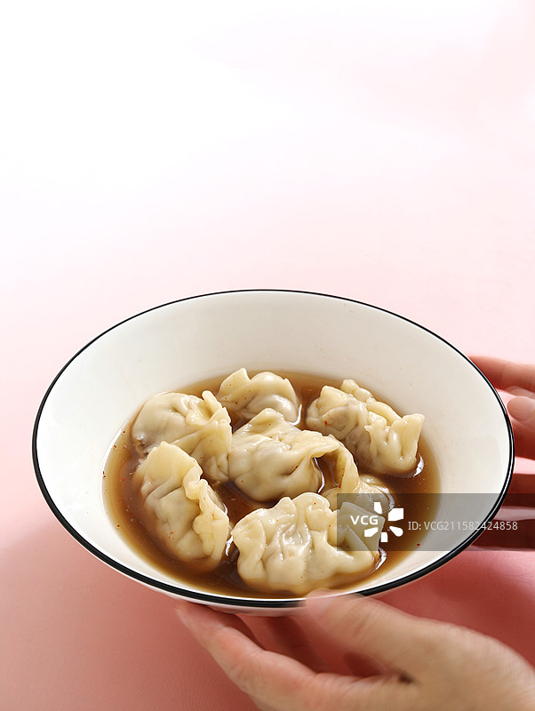 桌面上的一碗中国传统节日冬至春节美食饺子酸汤水饺图片素材