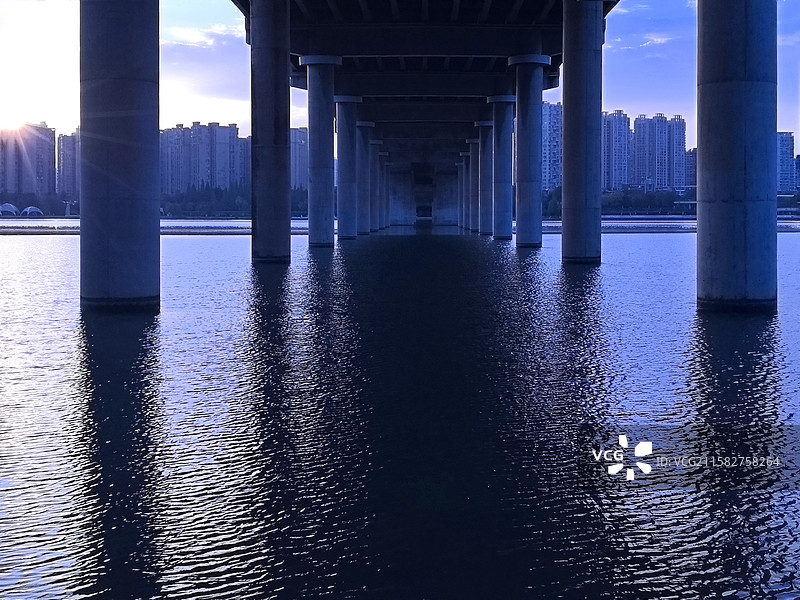 《四川遂宁市通德大桥的立柱》 桥影与立柱在水面交错，城市建筑静默伫立，一首关于黄昏与城市的抒情诗 。图片素材