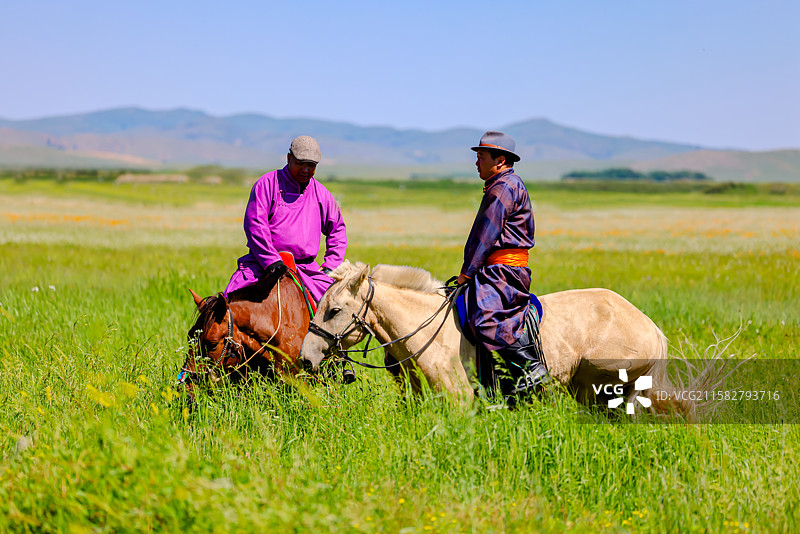 骑着马的蒙古人在草地上迎着天空图片素材