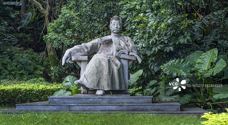 福州大学旗山校区里鲁迅身穿灰布长衫坐在沙发左手夹着雪茄右手松弛悬空斜搭扶手眼神犀利深邃睿智雕像正视图图片素材