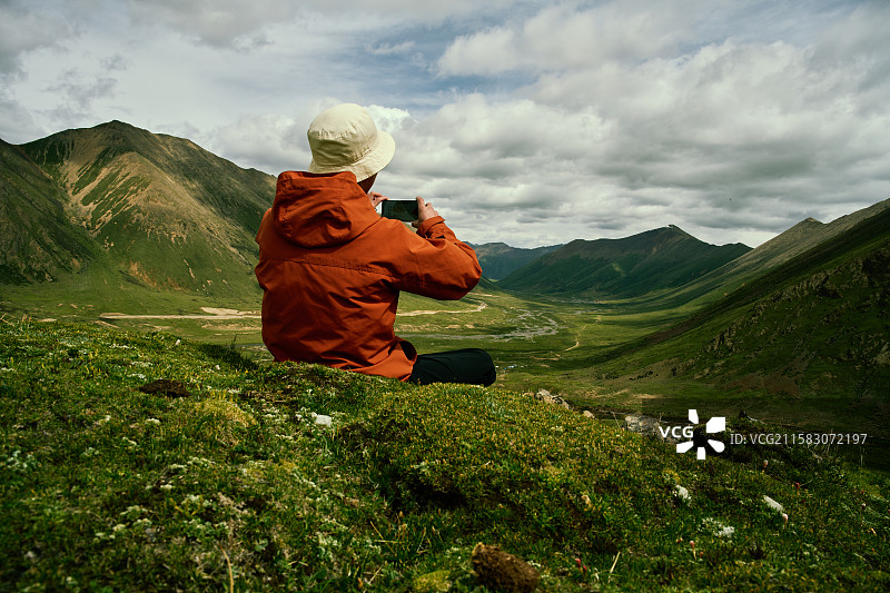 坐在山上的人的后视图图片素材