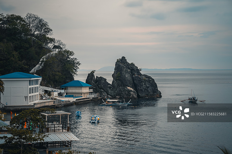 岩礁与蓝屋顶：阿尼洛的静谧海湾图片素材