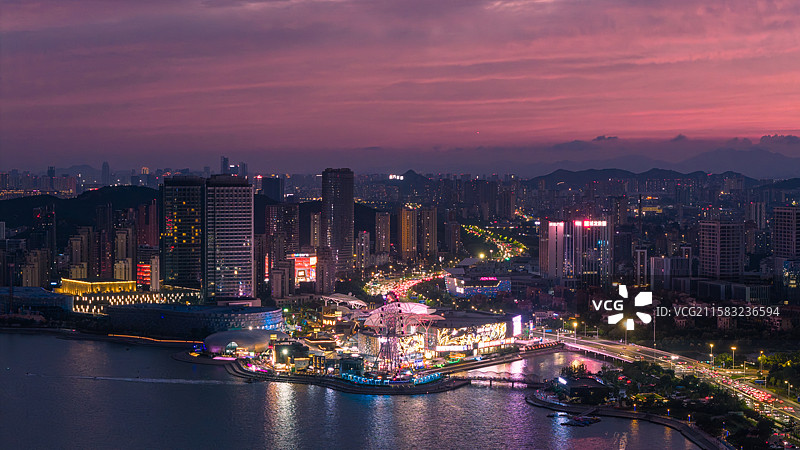 夏天傍晚蓝调时刻漫天火烧云晚霞下的青岛市黄岛区海岸线城市夜景图片素材