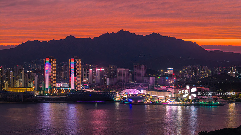 夏天傍晚蓝调时刻漫天火烧云晚霞下的青岛市黄岛区海岸线城市夜景图片素材