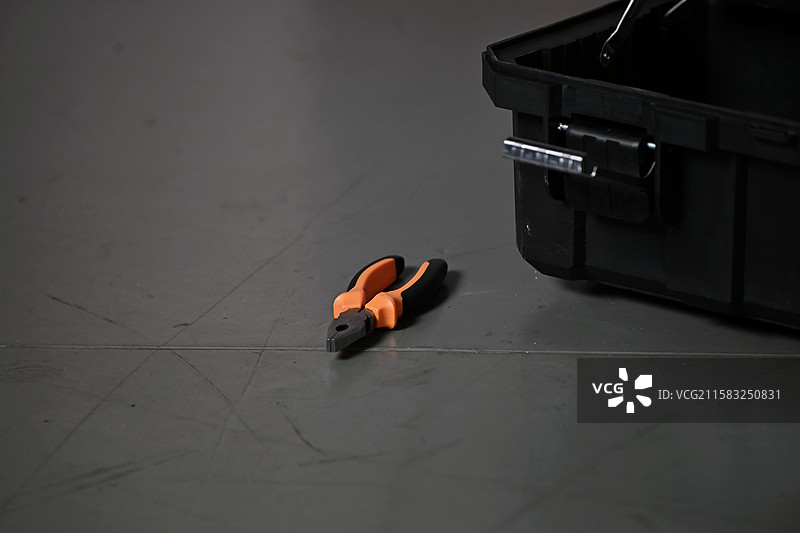 地面上的钳子，工具箱旁的钢丝钳，维修工具老虎钳的特写图片素材