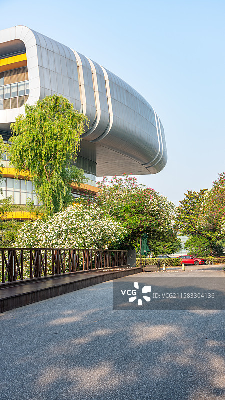 上海汽车博览公园夹竹桃花背景中的上海汽车博物馆建筑一角与汽车道路背景图图片素材