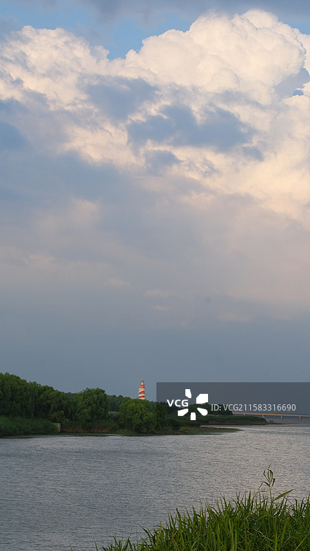 江苏文旅水乡金湖从后大圩拍摄远处航道的灯塔背景是一大片厚积云预示暴雨将至图片素材
