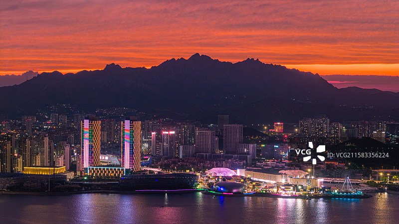 夏天傍晚蓝调时刻漫天火烧云晚霞下的青岛市黄岛区海岸线城市夜景图片素材