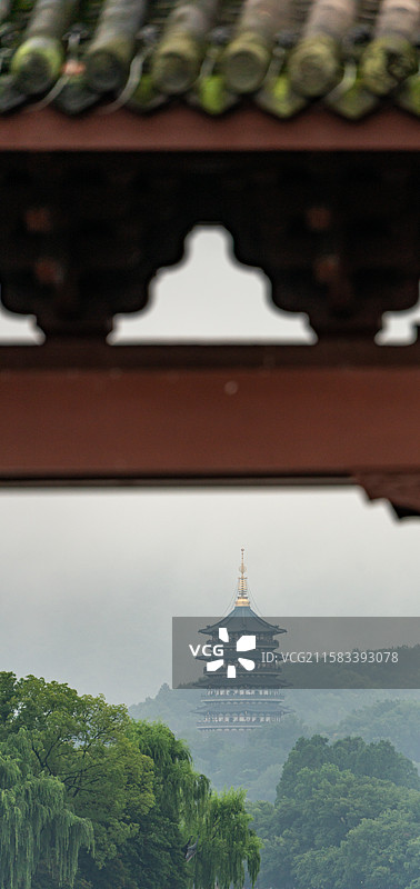 雨中的杭州西湖光华复旦牌坊建筑与雾色背景里的远山雷峰塔建筑湖面游船景观图片素材