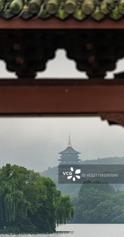 雨中的杭州西湖光华复旦牌坊建筑与雾色背景里的远山雷峰塔建筑湖面游船景观图片素材