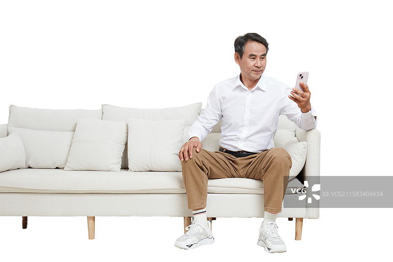 坐在沙发上的一个中老年男性拿手机自拍图片素材