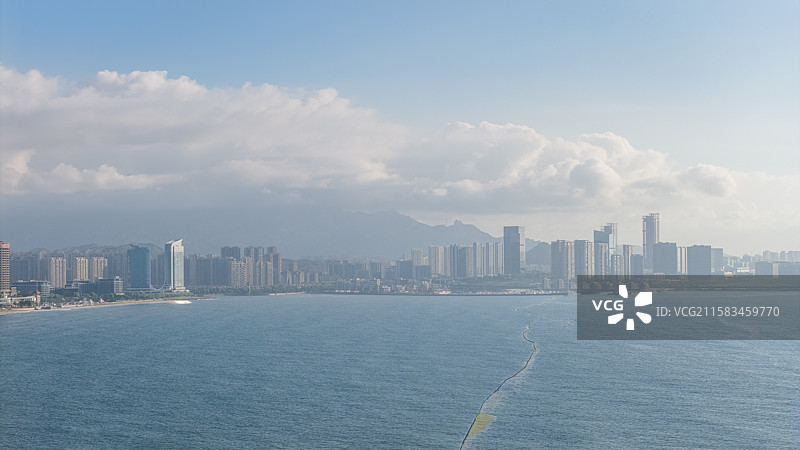 清晨日出时刻第一缕阳光照耀在青岛市黄岛区西海岸度假区标志性建筑群图片素材