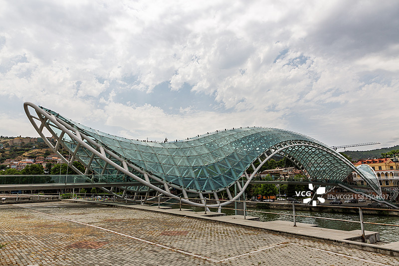 多云天空下的现代建筑，格鲁吉亚第比利斯库拉河上的和平桥图片素材