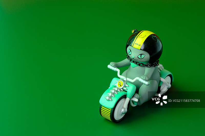 绿色背景下骑摩托车的猫。悦星喵星人天蝎星座。设计素材图片素材