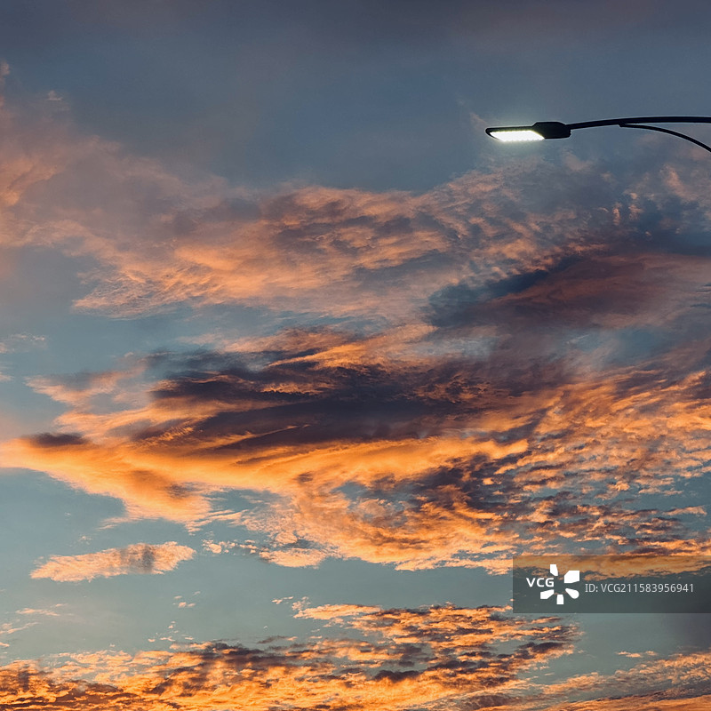 路灯刺破暮色，云霞在天空晕染成画。这一刻，喧嚣被按下暂停键，连风都慢下来，陪我看这一场温柔的黄昏谢幕图片素材