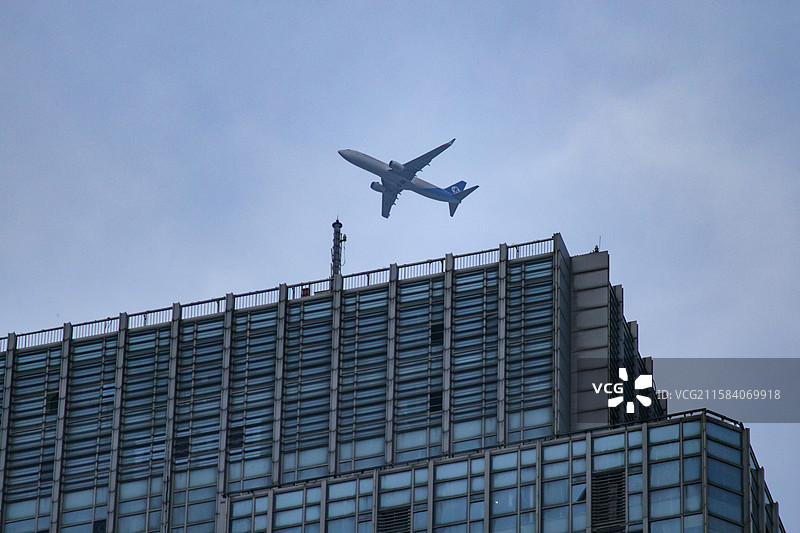 越过高楼的飞机图片素材