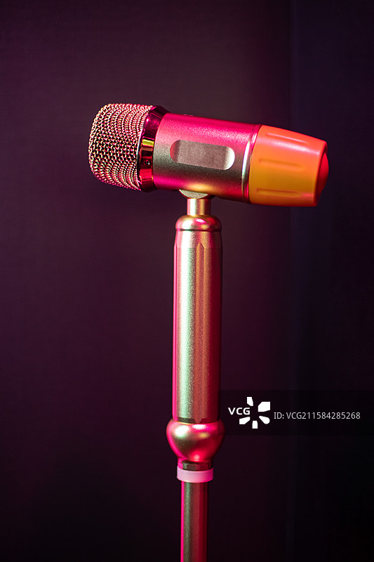 中国休闲娱乐拍摄主题，KTV里的立式麦克风金属话筒和背景的电视机屏幕，室内无人图像摄影图片素材