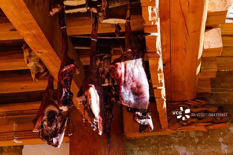 木梁下悬挂的腌制猪肉图片素材