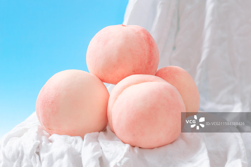 粉嫩水蜜桃堆叠于白布上图片素材
